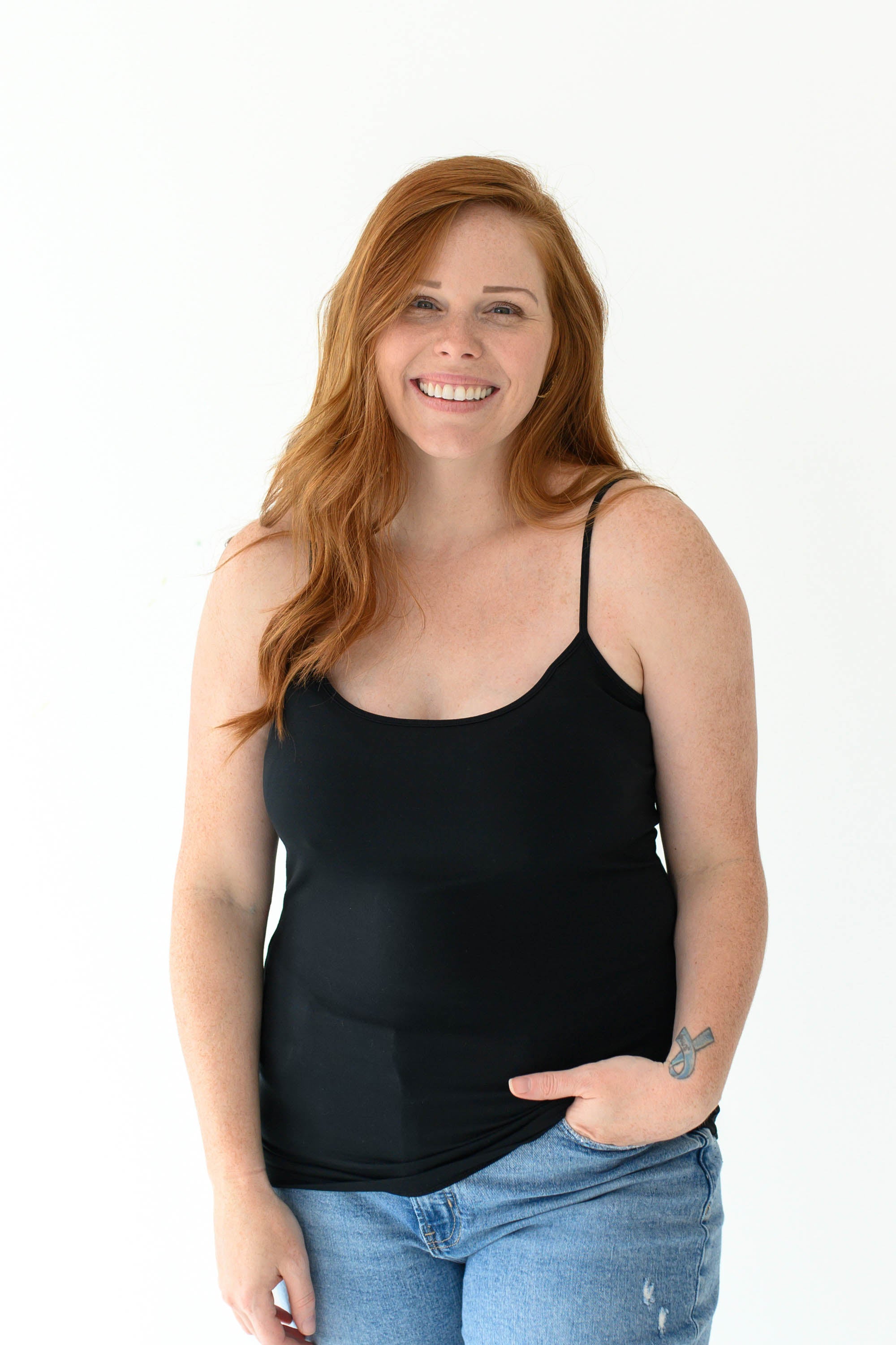 Female model wearing the Women’s Camisole in Midnight paired with medium wash jeans