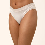 Person wearing light beige underwear on a beige background