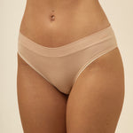 Beige underwear worn by a person on a beige background