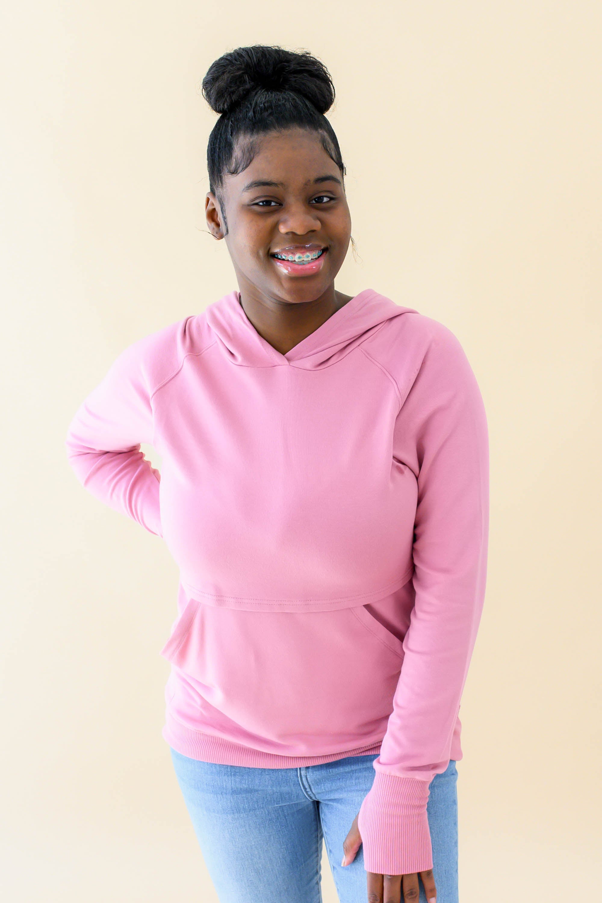 Female wearing the Women's French Terry Nursing Hoodie in Apple Blossom paired with light wash jeans