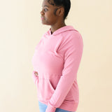 Female wearing the Women's French Terry Nursing Hoodie in Apple Blossom and light wash jeans