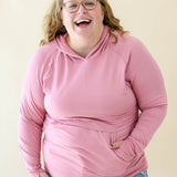 Female wearing the Women's French Terry Nursing Hoodie in Apple Blossom in light wash jeans