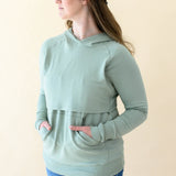 Model wearing the Women's French Terry Nursing Hoodie in Thyme with both hands in the pocket