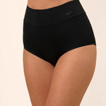 Black high-waisted bamboo underwear worn by a person on a beige background