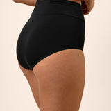 Black high-waisted bamboo underwear worn by a person on a beige background showing side coverage