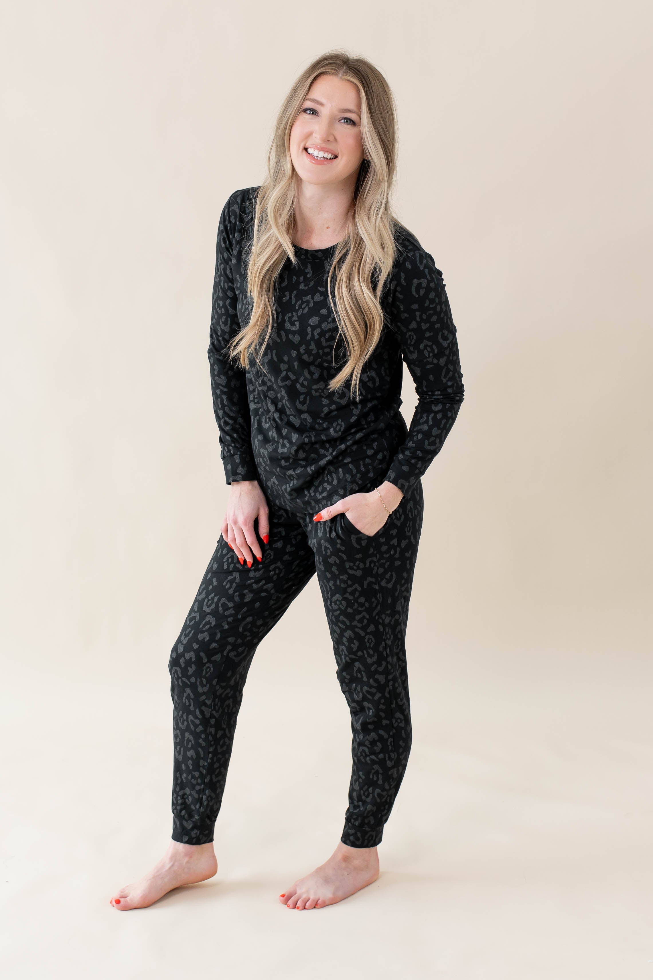 Smiling model wearing Women's Jogger Pajama Set in Midnight Leopard with one hand in pant pocket