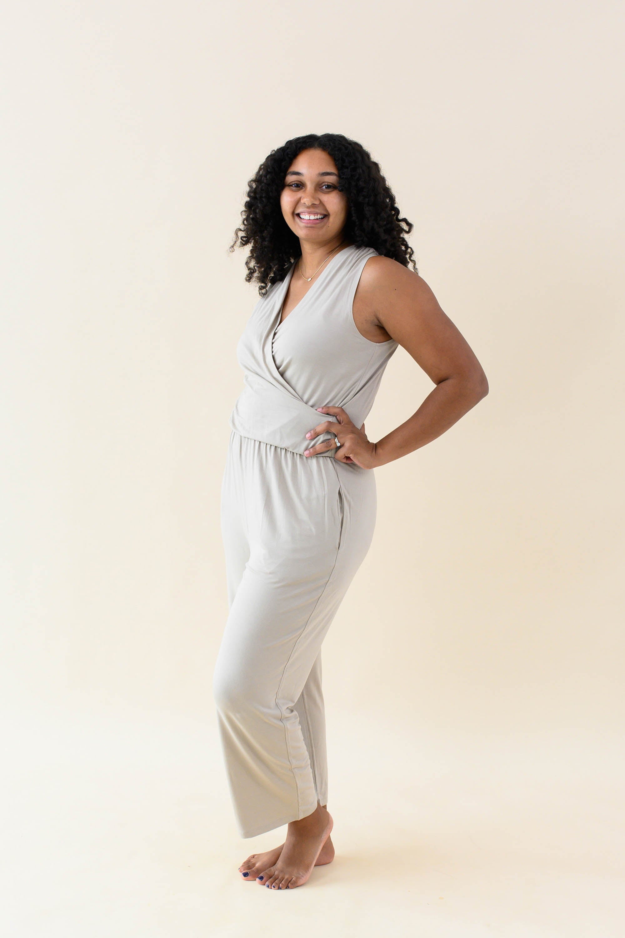 Model wearing the Women's Jumpsuit in Almond with one hand on hip