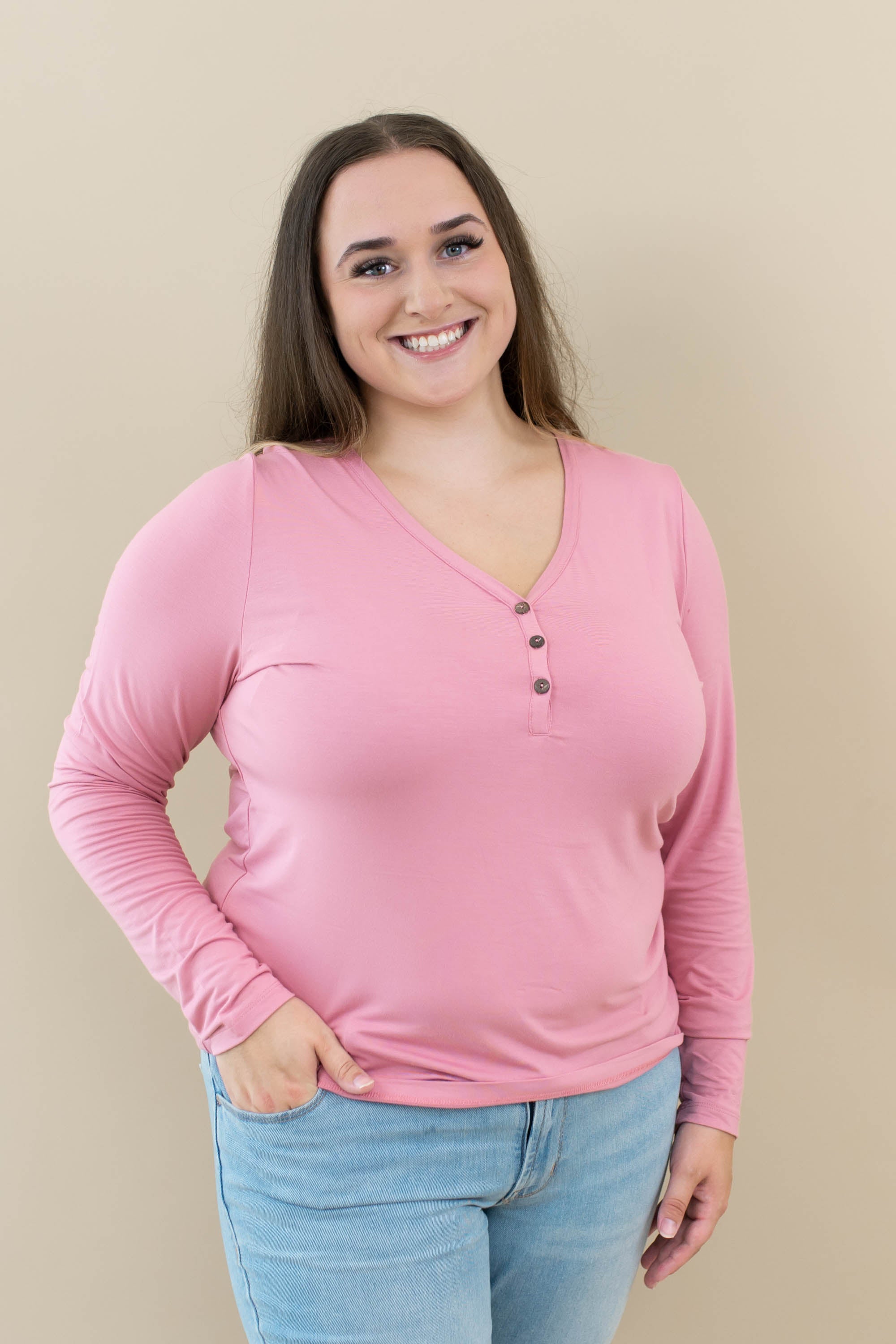 Female wearing Women's Long Sleeve Henley Tee in Apple Blossom with light wash jeans