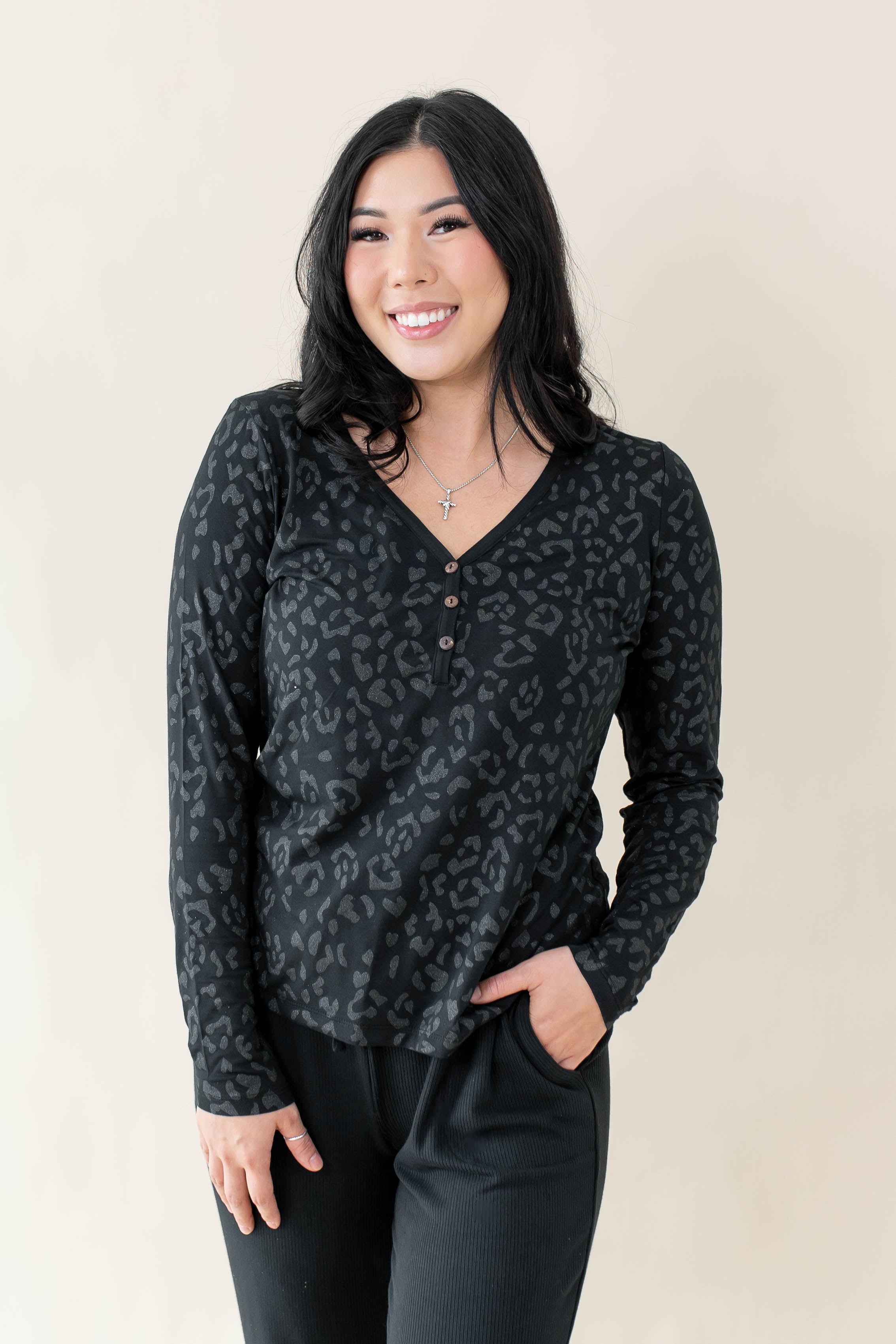 Female modeling the Women's Long Sleeve Henley Tee in Midnight Leopard