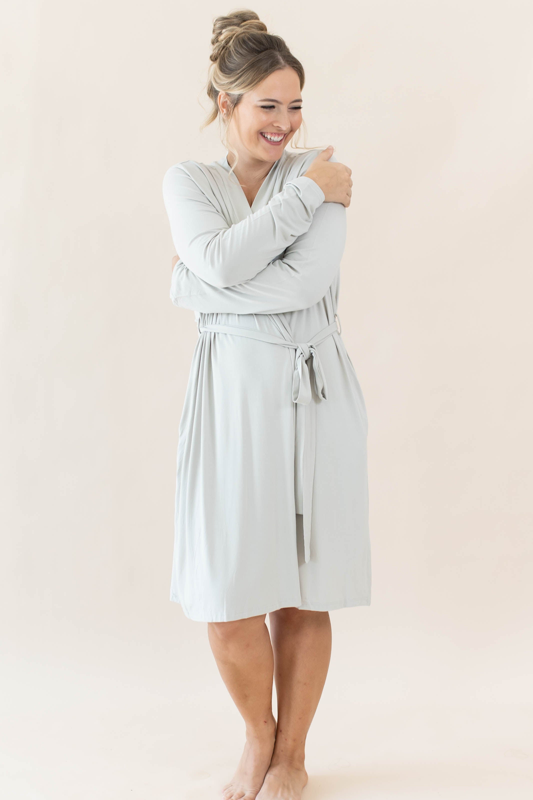 Female model hugging herself wearing the Women’s Lounge Robe in Oat