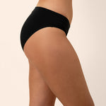 Black bamboo midi brief underwear worn by a person on a beige background showing side coverage