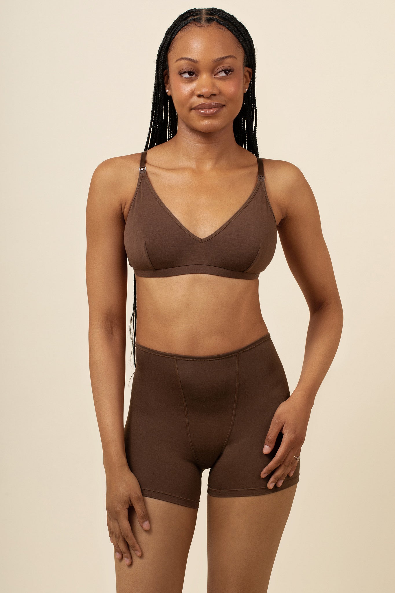 Woman wearing a brown bra and shorts set on a beige background
