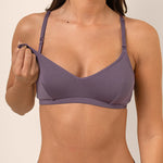 Woman wearing a purple nursing bra showing the nursing clips feature for pull-down access 
