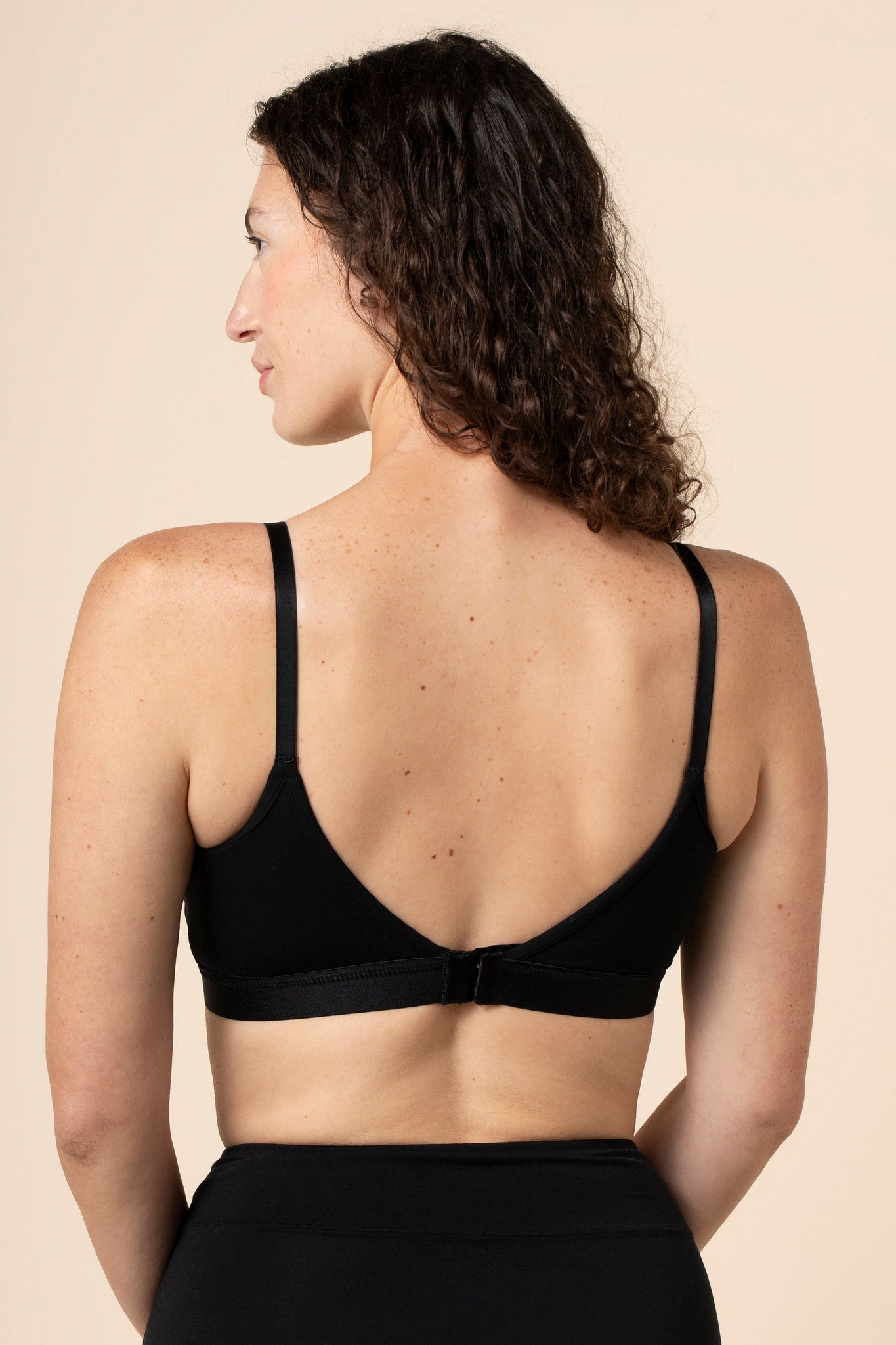 Model show casing the back side and straps of the Women's Pumping Bra in Midnight 