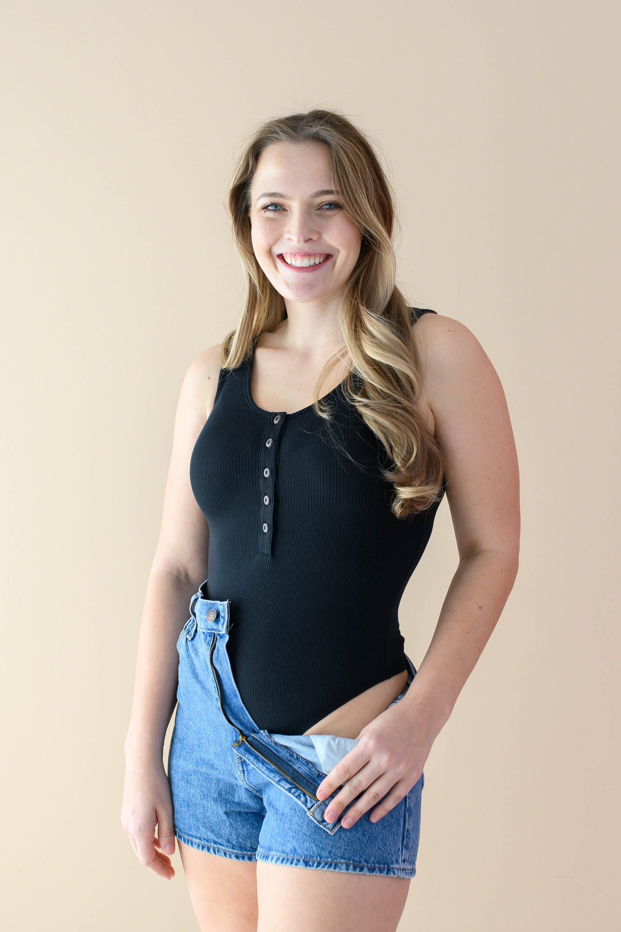Female displaying the bodysuit cut of the Women’s Ribbed Henley Bodysuit in Midnight