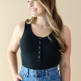 Smiling female wearing the Women’s Ribbed Henley Bodysuit in Midnight
