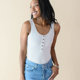 Female wearing the Women’s Ribbed Henley Bodysuit in Oat paired with jeans