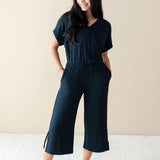 Smiling model wearing the Women's Ribbed Jumpsuit in Midnight with both hands in pockets