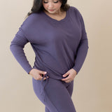 Female showing the drawstring feature on the bottom of the shirt for cinching for the Women's Ribbed Long Sleeve Drop Shoulder Top in Currant