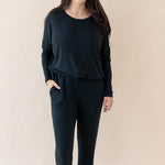 Female modeling the Women's Ribbed Long Sleeve Drop Shoulder Top in Midnight paired with Midnight Wide Leg Pants