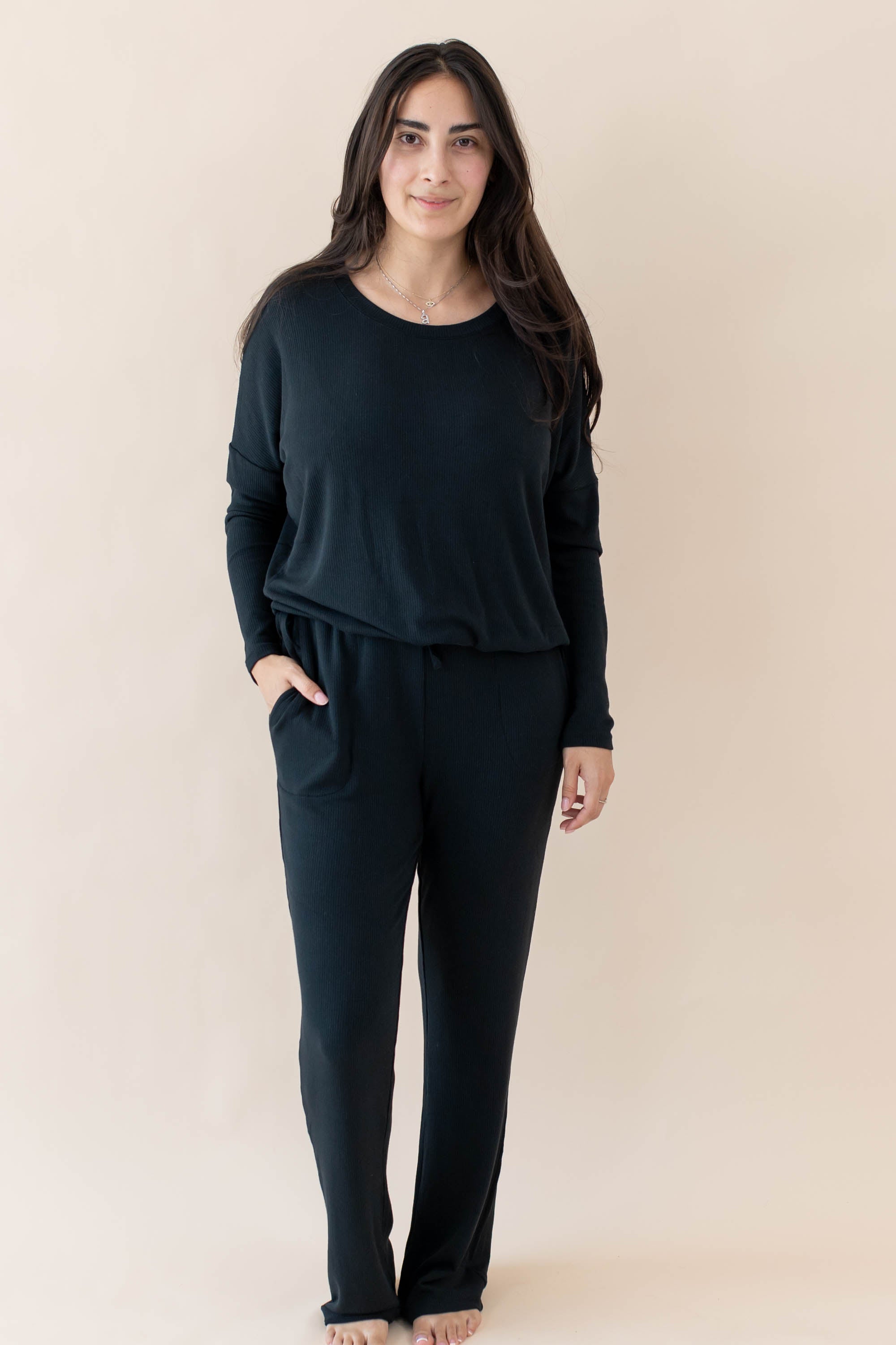 Female modeling the Women's Ribbed Long Sleeve Drop Shoulder Top in Midnight paired with Midnight Wide Leg Pants