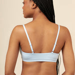 Model showcasing the back and straps of the Women's Scoop Neck Bralette in Breeze  paired with matching briefs 