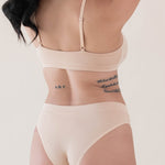 Female modeling the back of the Women's Scoop Neck Bralette in Chai