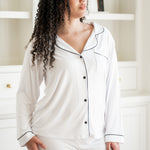 Woman wearing white pajamas with black trim in a room. ::: Model is 5'9" wearing size L ///