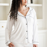 Woman wearing white pajamas with black trim in a room. ::: Model is 5'9" wearing size L ///