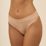 Beige thong underwear on a beige background