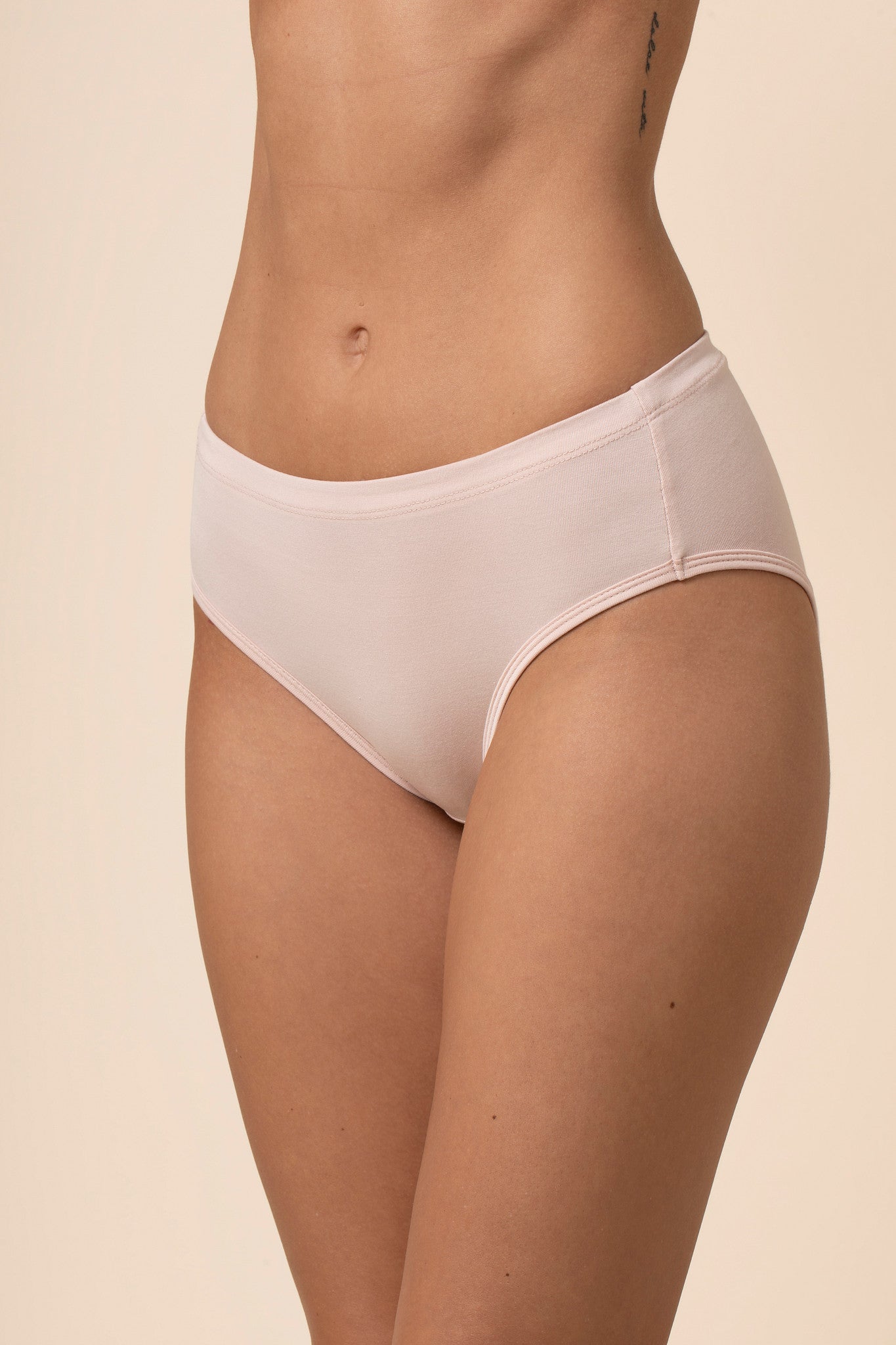 Light pink mid-waisted underwear on a beige background