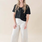 Model wearing the Women's Relaxed Fit V-Neck in Midnight Leopard paired with white jeans