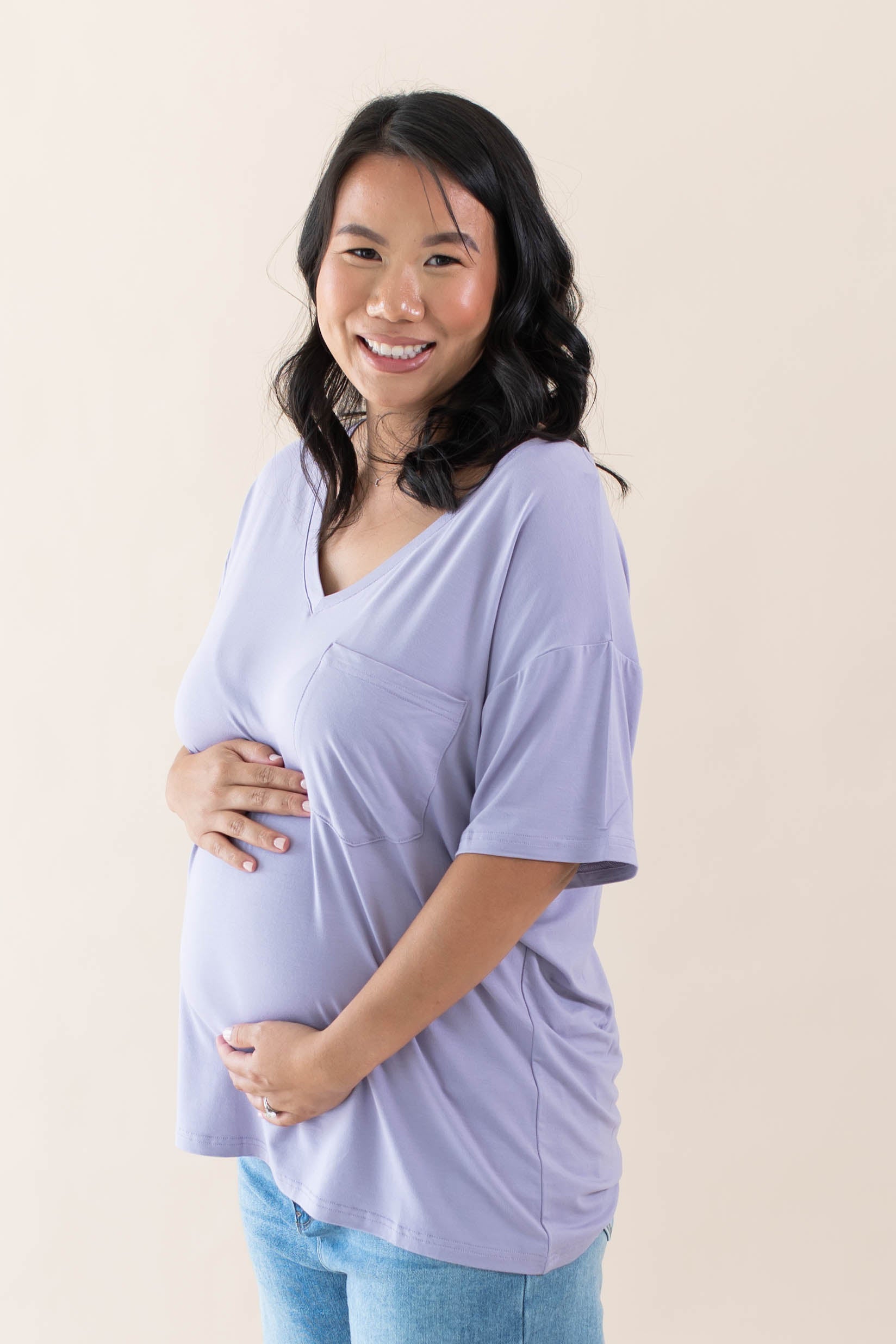 Expectant mother cradling her baby bump wearing the Women’s Relaxed Fit V-Neck in Taro