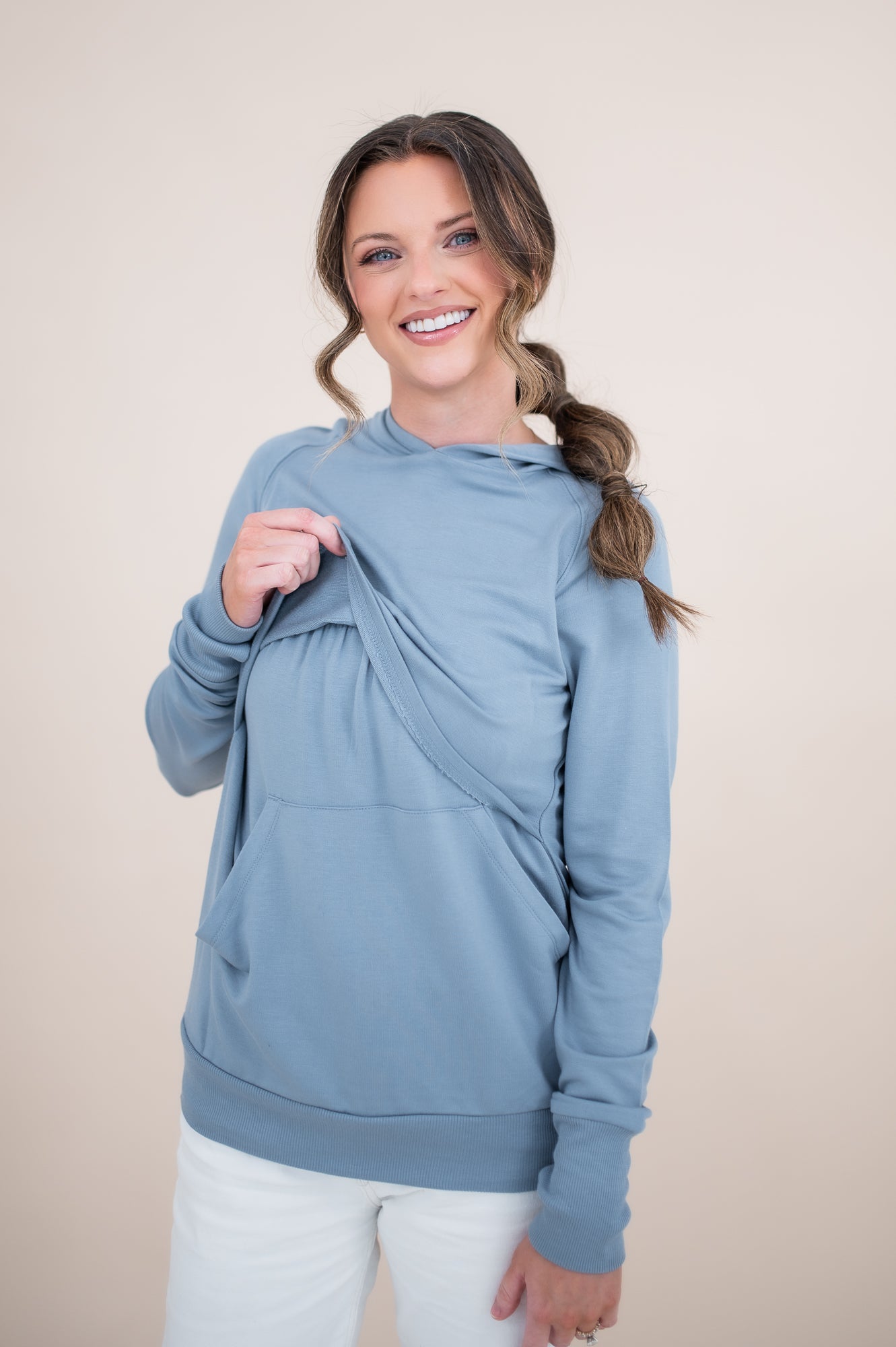 Female modeling the Women's French Terry Nursing Hoodie in Slate lifting the front fabric of the hoodie