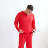 Man adjusting bottom of Men's Long Sleeve Henley Top in Cardinal