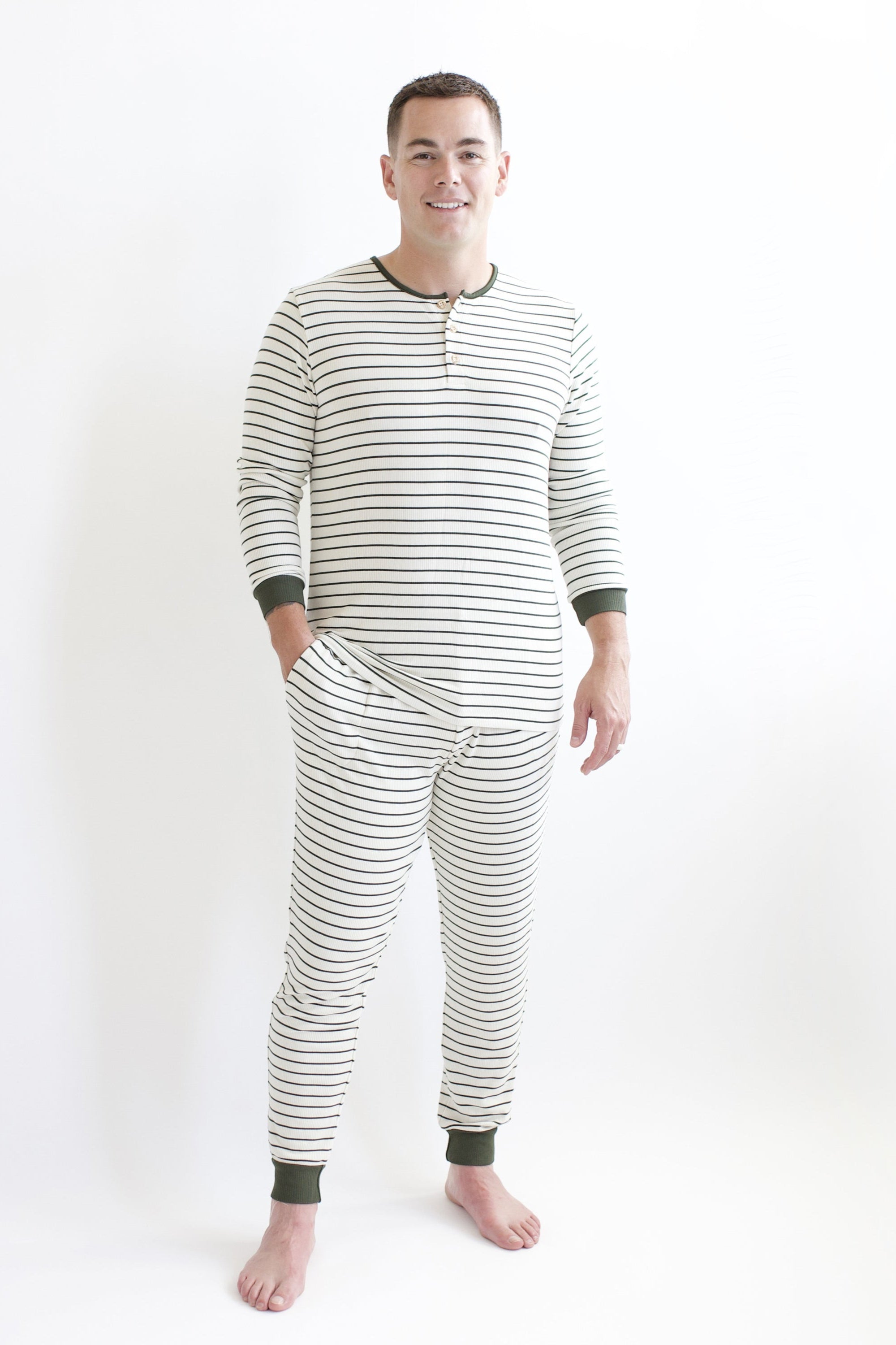 Male model wearing the Men's Ribbed Henley Set in Fir Stripe standing in front of a white backdrop