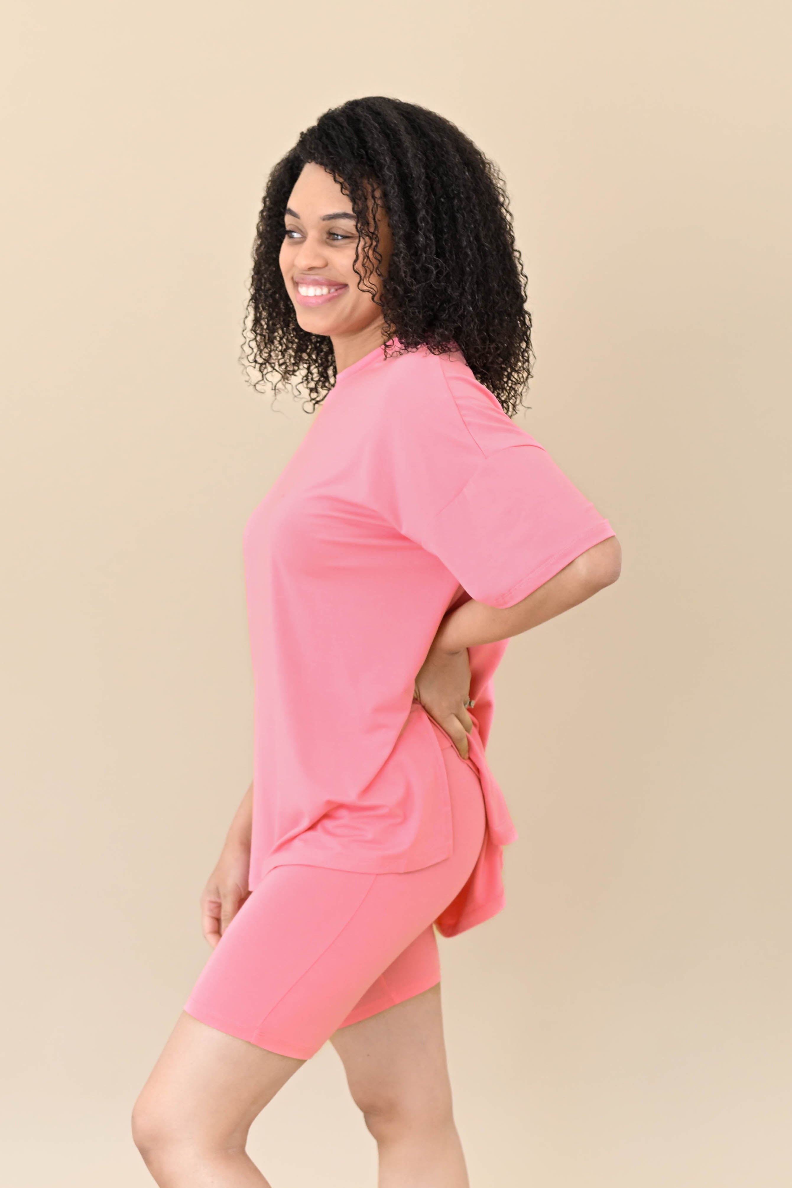Female modeling the side view of the Women’s Biker Short Set in Guava