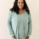 Female modeling the Bamboo Jersey Adult Cardigan in Thyme wearing a Thyme Shirt and Oat pants