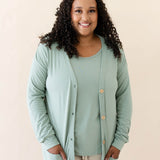 Female modeling the Bamboo Jersey Adult Cardigan in Thyme wearing a Thyme Shirt and Oat pants