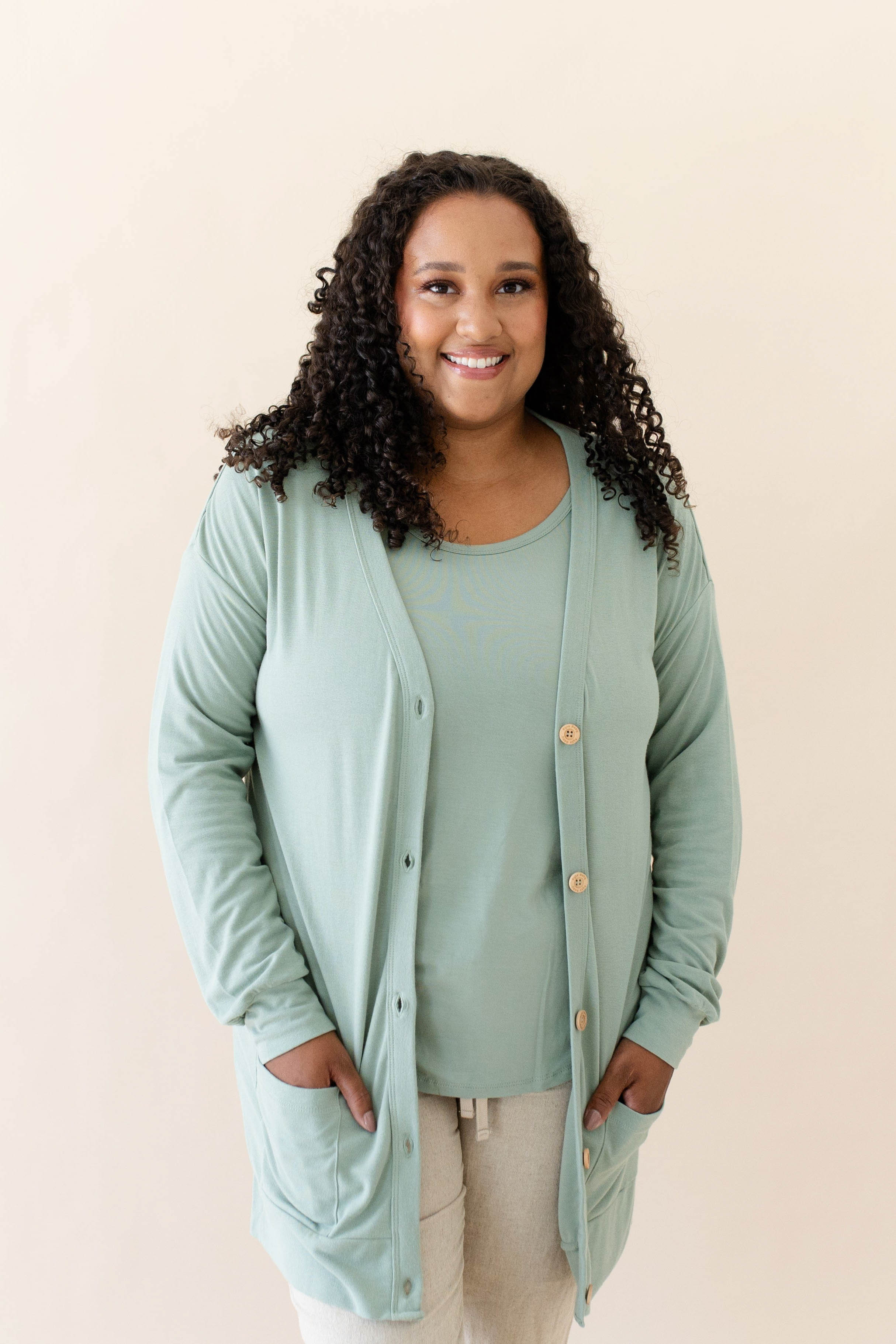 Female modeling the Bamboo Jersey Adult Cardigan in Thyme wearing a Thyme Shirt and Oat pants