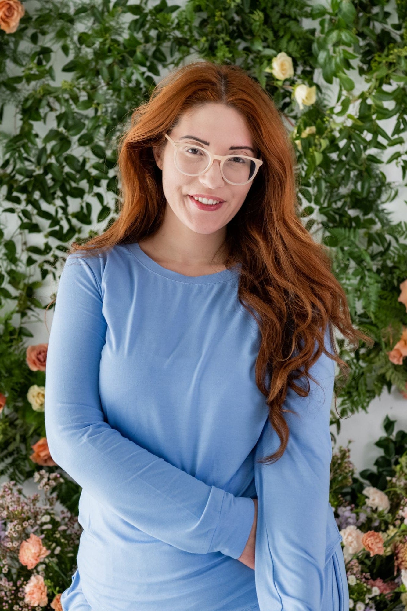 Close up of woman modeling periwinkle blue color jogger pajama set with greenery in background
