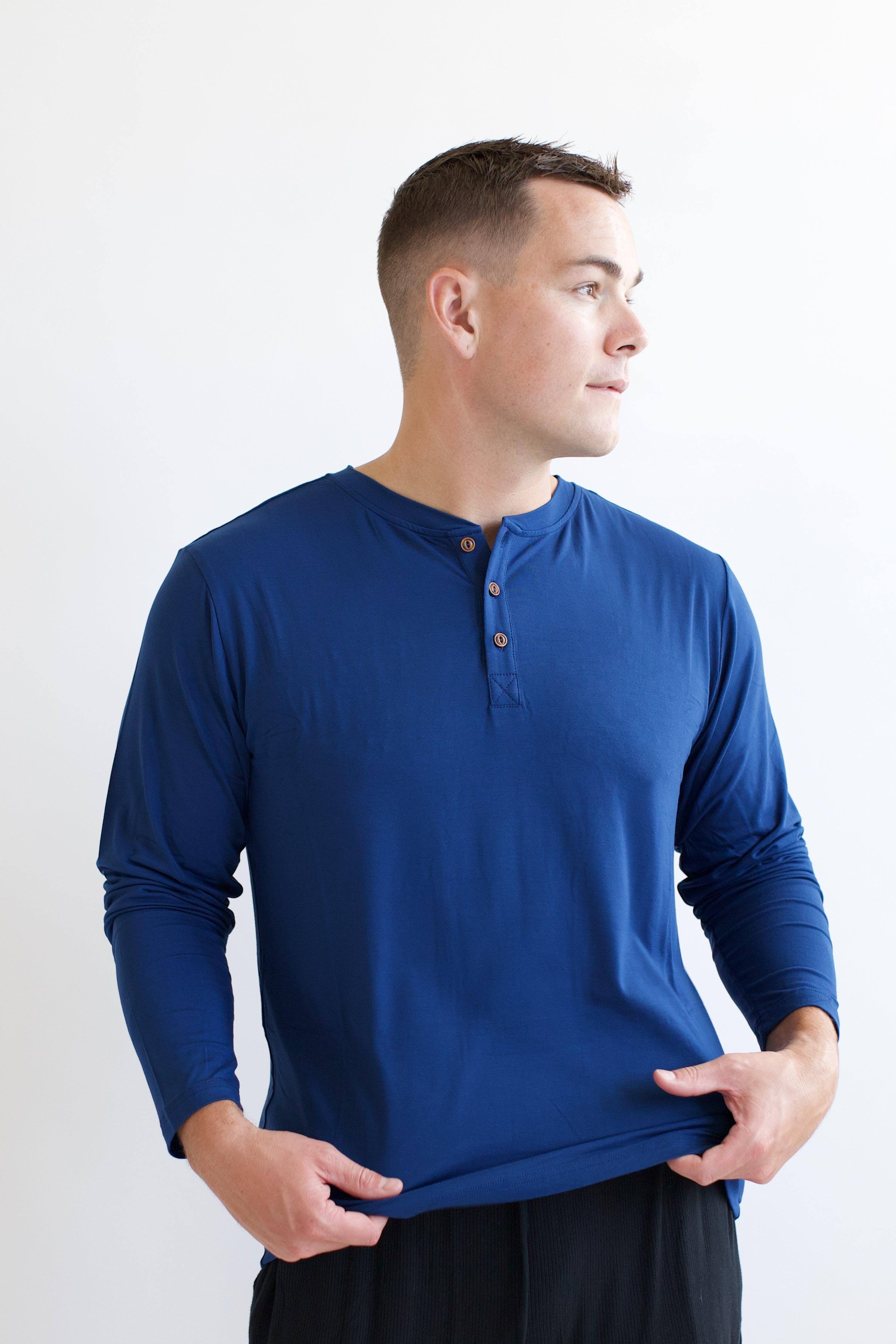 Male model looking to the side while wearing the Men's Long Sleeve Henley Top in Tahoe