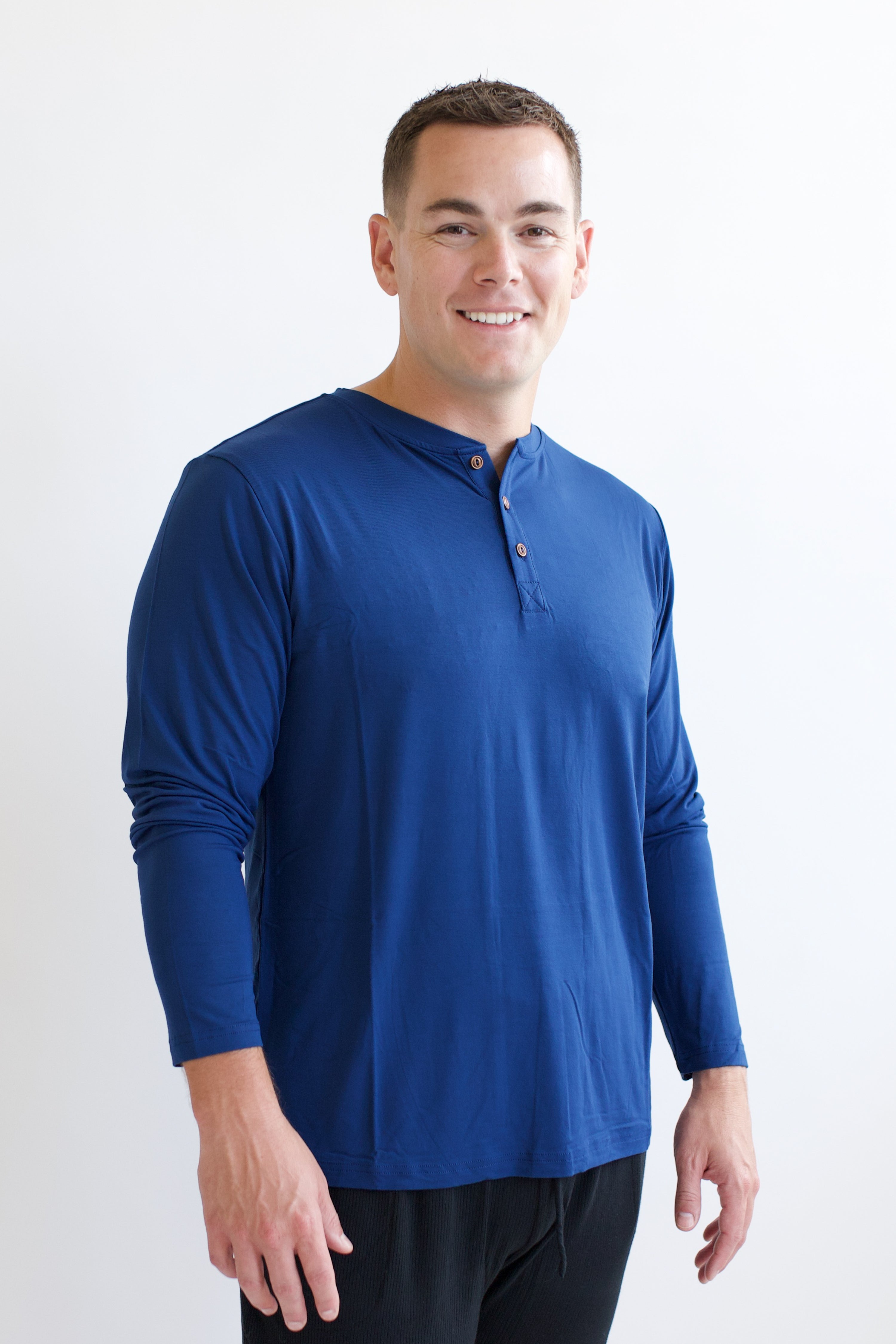 Smiling man modeling the Kyte Men's Long Sleeve Henley Top in Tahoe