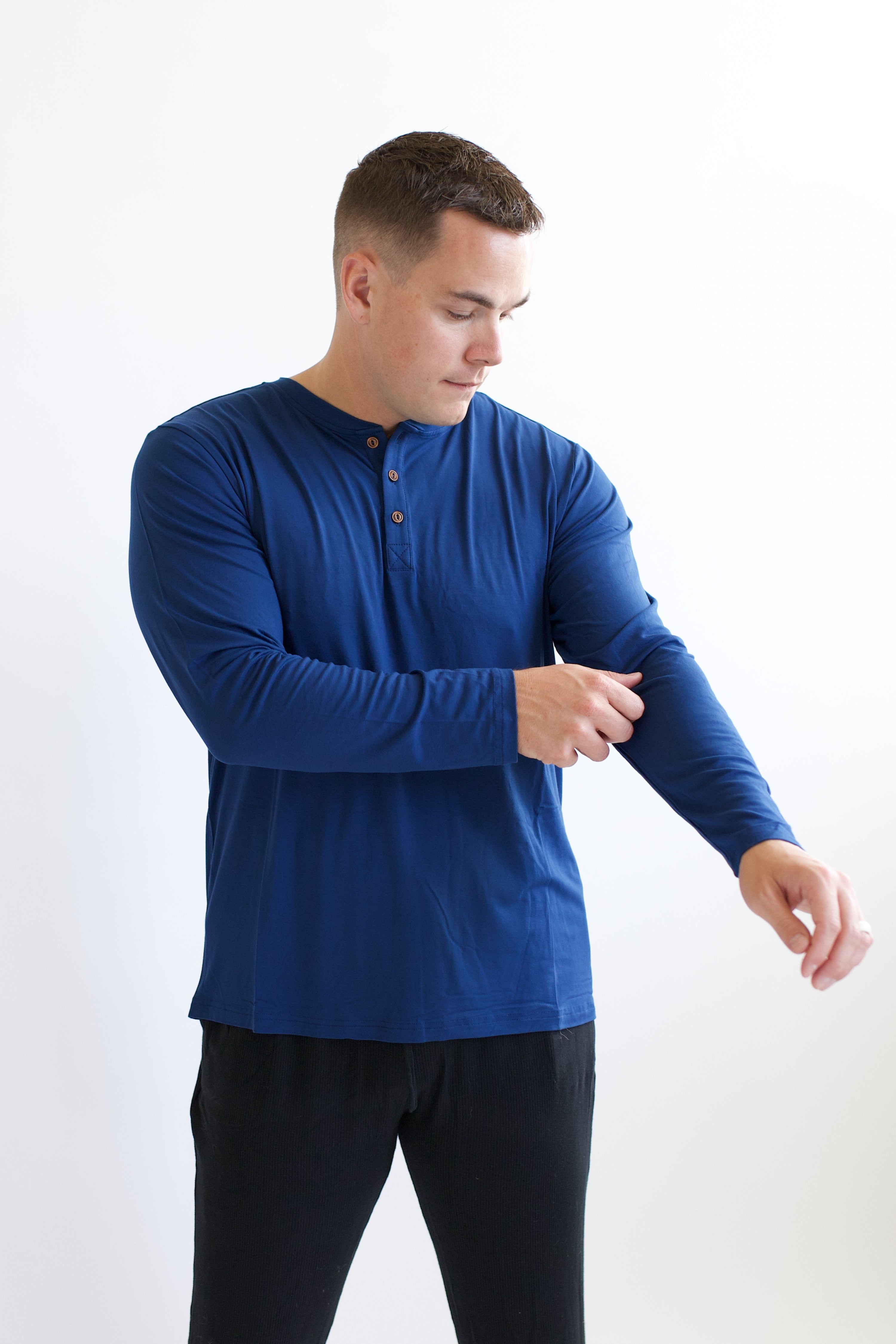 Model fixing sleeve on the Kyte Men's Long Sleeve Henley Top in Tahoe