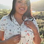 Women in Road Trip short sleeve pajama set from Kyte Living walking around in an outdoor settng