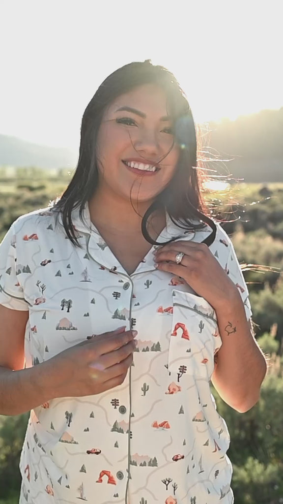 Women in Road Trip short sleeve pajama set from Kyte Living walking around in an outdoor settng