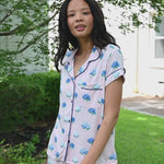 Woman outside looking over her shoulder in short sleeve and short pajamas in Hydrangea Sakura print. ::: Model is 5'10" wearing size S ///
