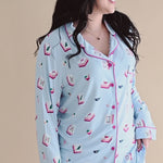Woman modeling long sleeve button up blue pajama set with mahjong tile pattern ::: Model is 5'6" wearing size M ///