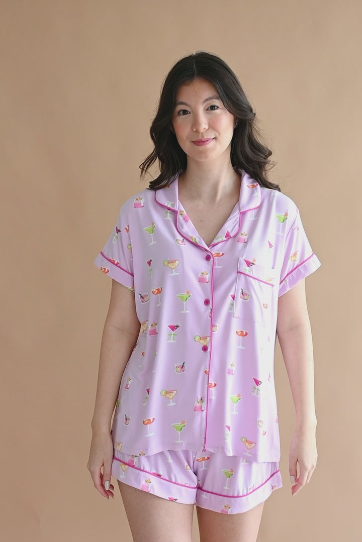Video of model wearing pink purple short sleeve pajama set with cocktail print
