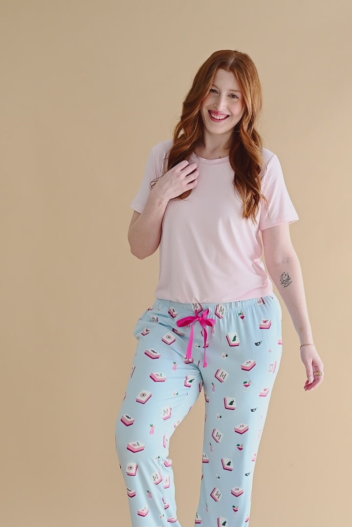 Woman modeling a lounge pant with mahjong tile pattern and light pink tshirt 